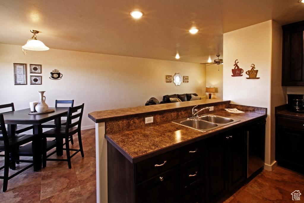 Kitchen with kitchen peninsula, black dishwasher, dark tile floors, sink, and pendant lighting