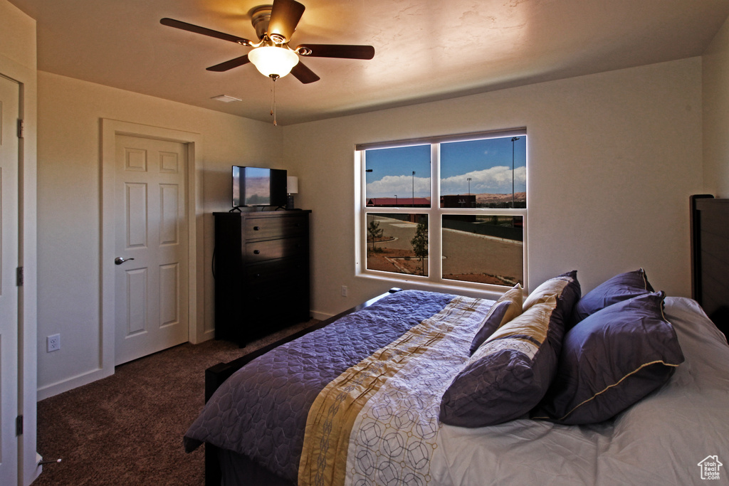 Bedroom with dark carpet and ceiling fan