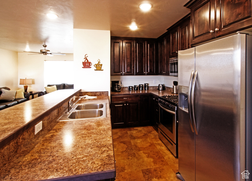 Kitchen with appliances with stainless steel finishes, ceiling fan, dark tile floors, sink, and dark brown cabinets