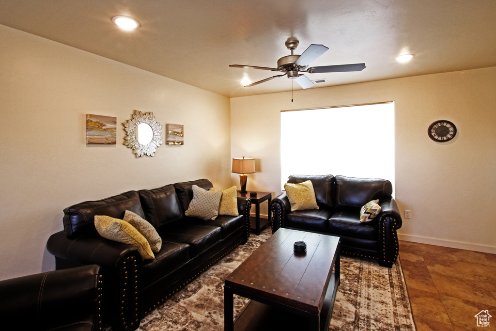 Living room featuring dark tile floors and ceiling fan