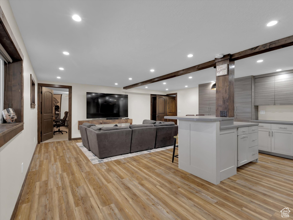 Kitchen featuring light hardwood / wood-style floors, a center island, white cabinetry, and a kitchen breakfast bar