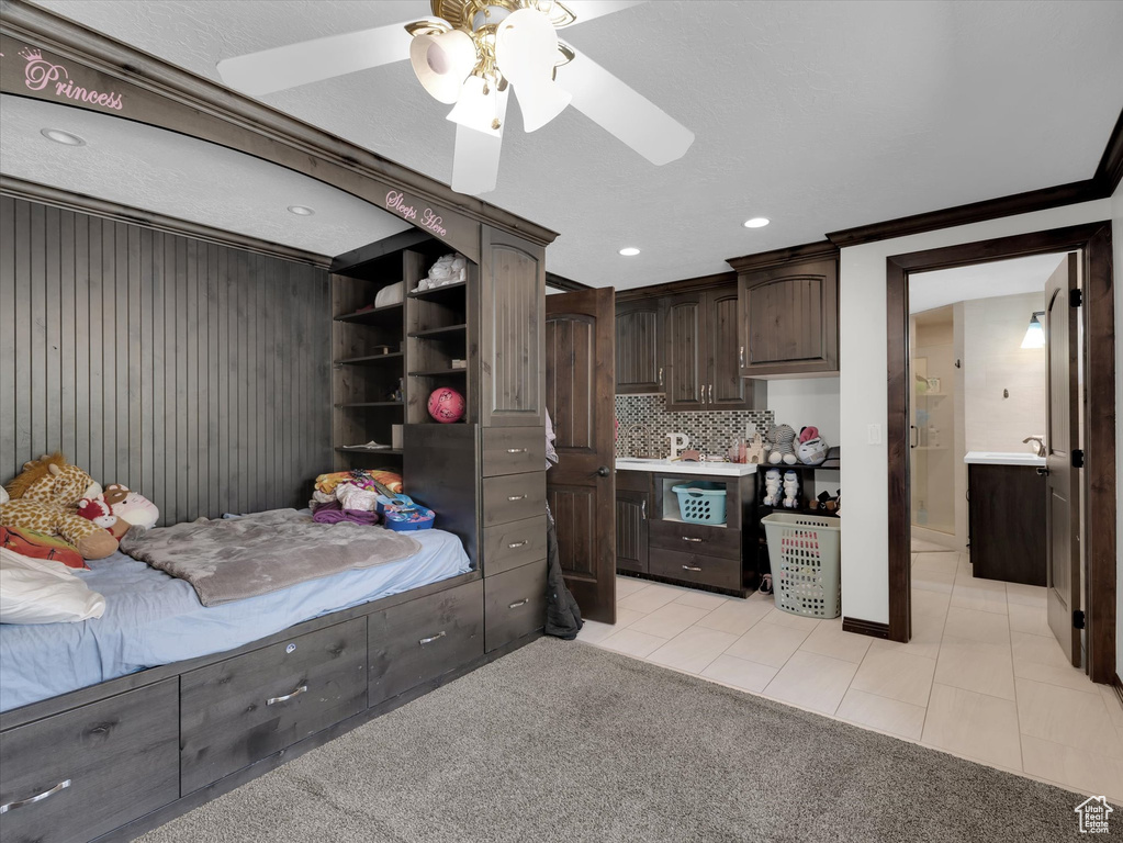 Tiled bedroom featuring ornamental molding and ceiling fan