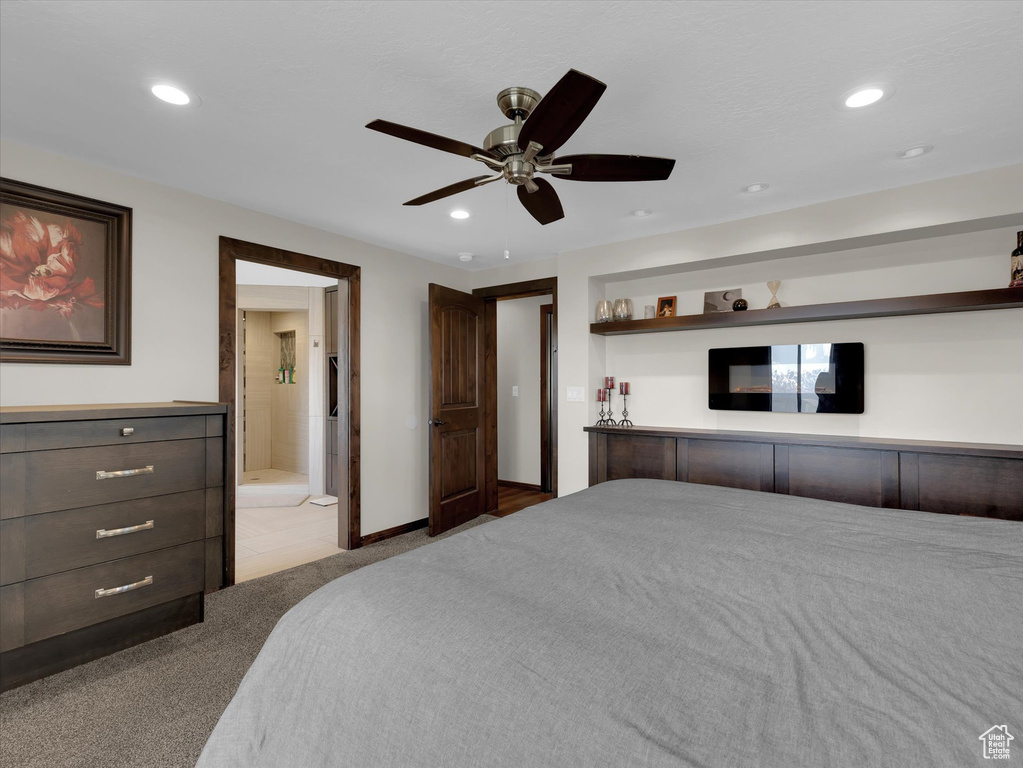 Bedroom with light carpet, ceiling fan, and ensuite bathroom