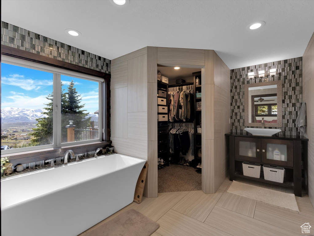Bathroom with tile walls, vanity, and tile floors