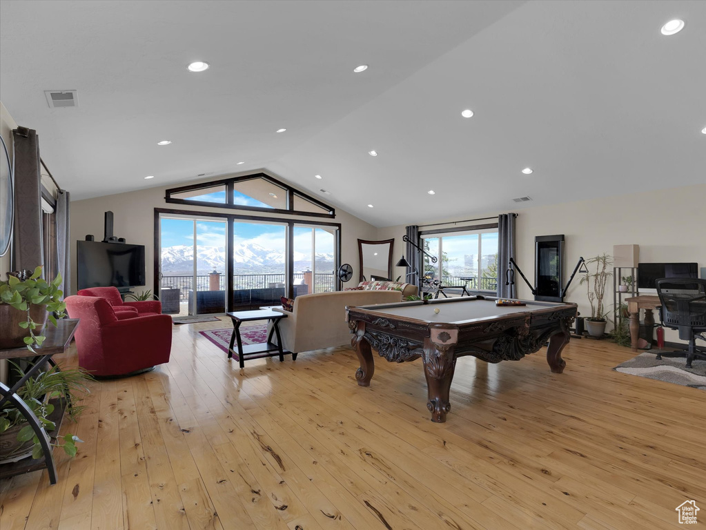 Rec room with vaulted ceiling, light hardwood / wood-style floors, and pool table