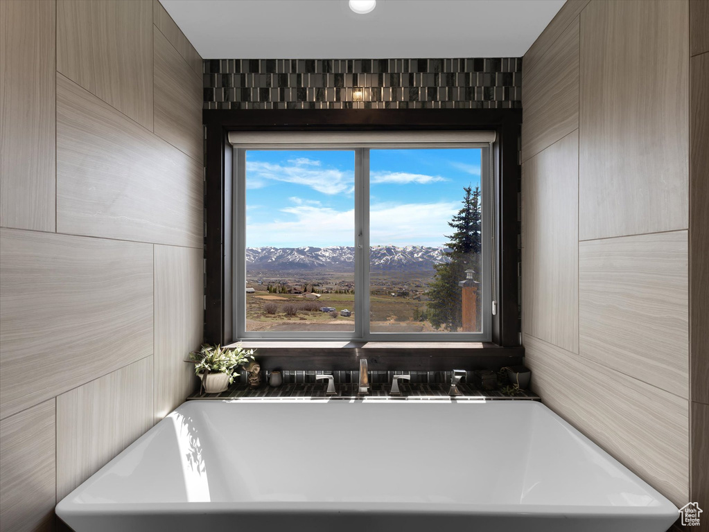 Bathroom featuring a mountain view, plenty of natural light, and tile walls