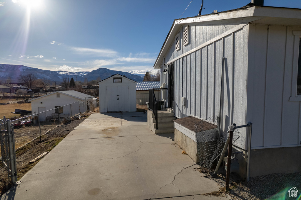 Exterior space featuring a mountain view, a shed, and a patio area