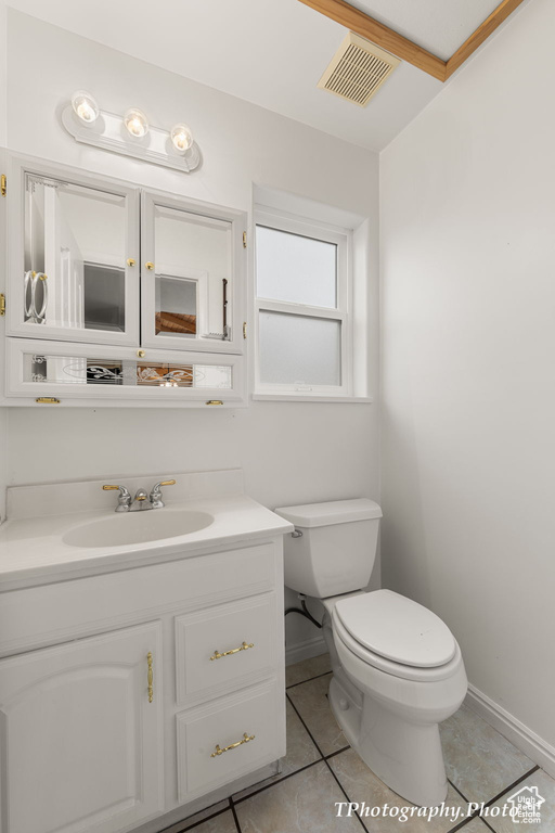 Bathroom with tile flooring, large vanity, and toilet