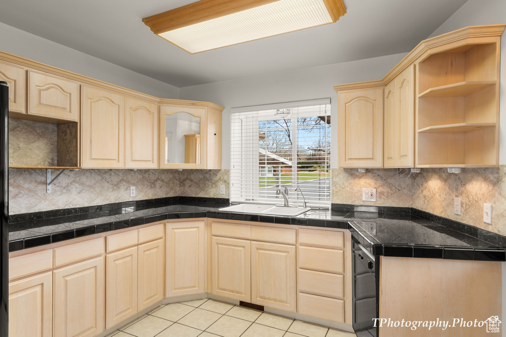 Kitchen with sink, tasteful backsplash, light tile floors, and light brown cabinets