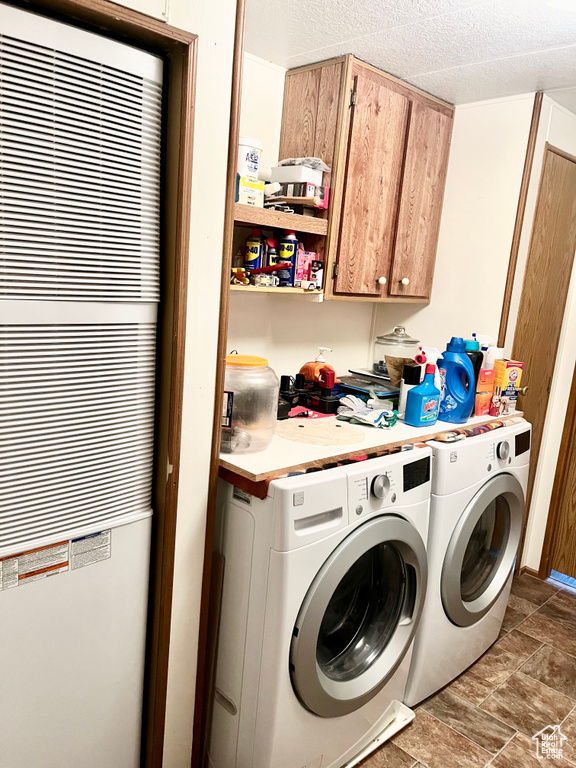 Laundry area with separate washer and dryer, cabinets, and dark tile flooring