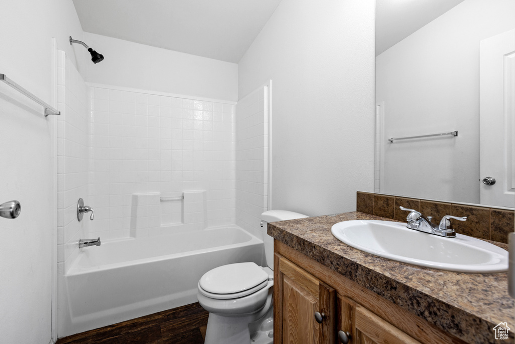 Full bathroom featuring vanity, shower / bath combination, wood-type flooring, and toilet