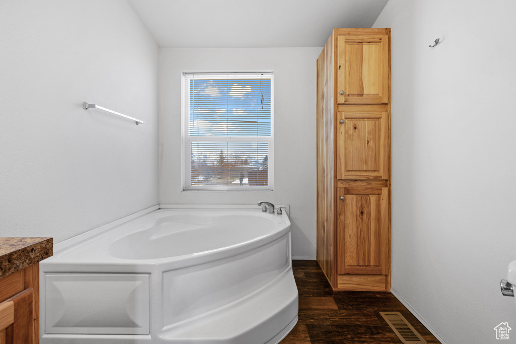 Bathroom featuring a bathtub, wood-type flooring, and vanity