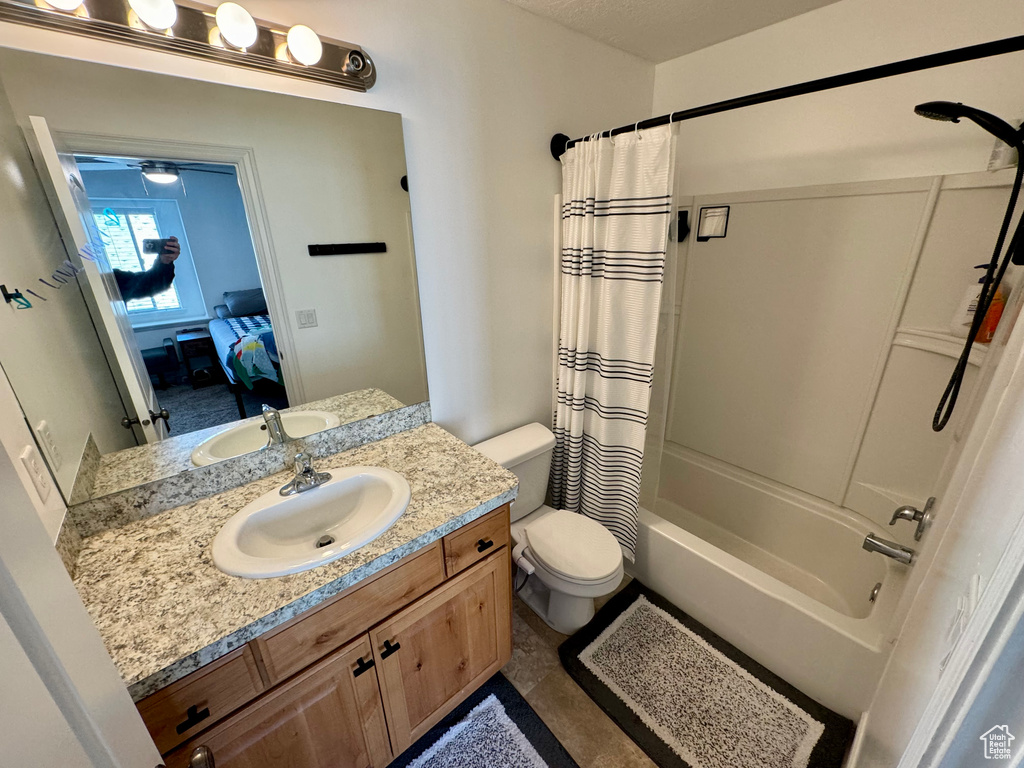 Full bathroom with vanity, toilet, shower / bath combo, and tile floors