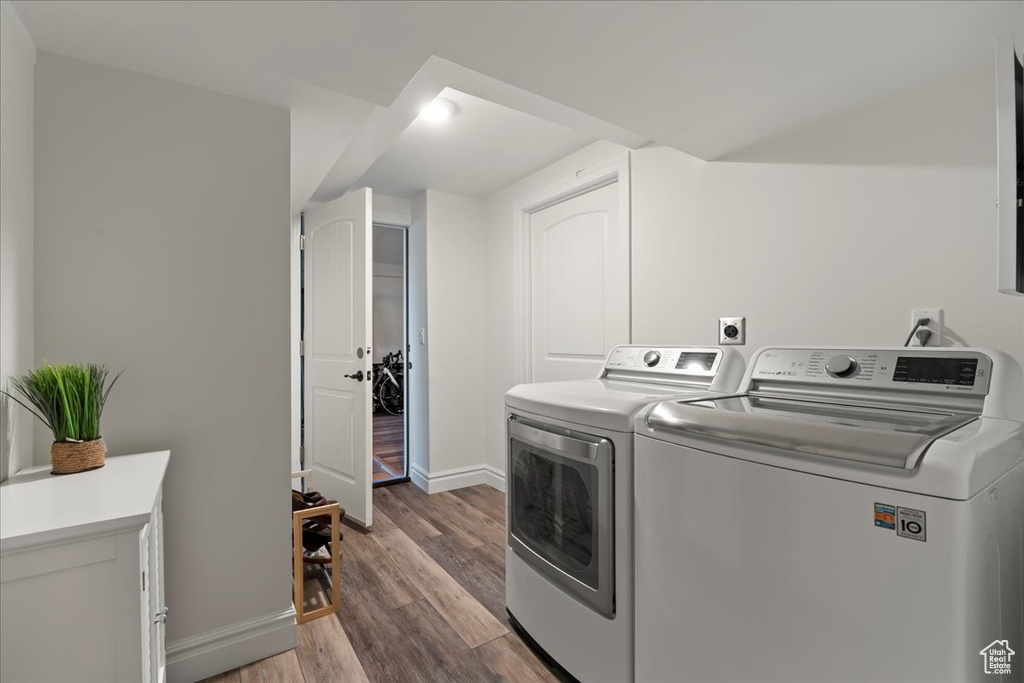 Laundry room with dark wood-type flooring, electric dryer hookup, and washing machine and dryer