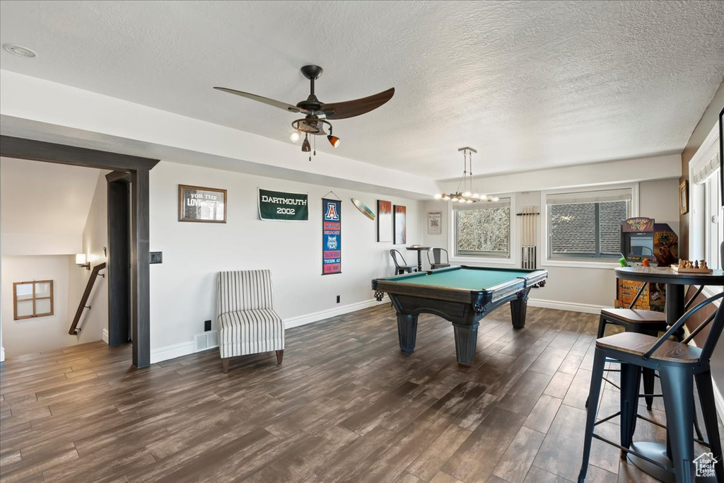Rec room with ceiling fan with notable chandelier, a healthy amount of sunlight, a textured ceiling, and billiards