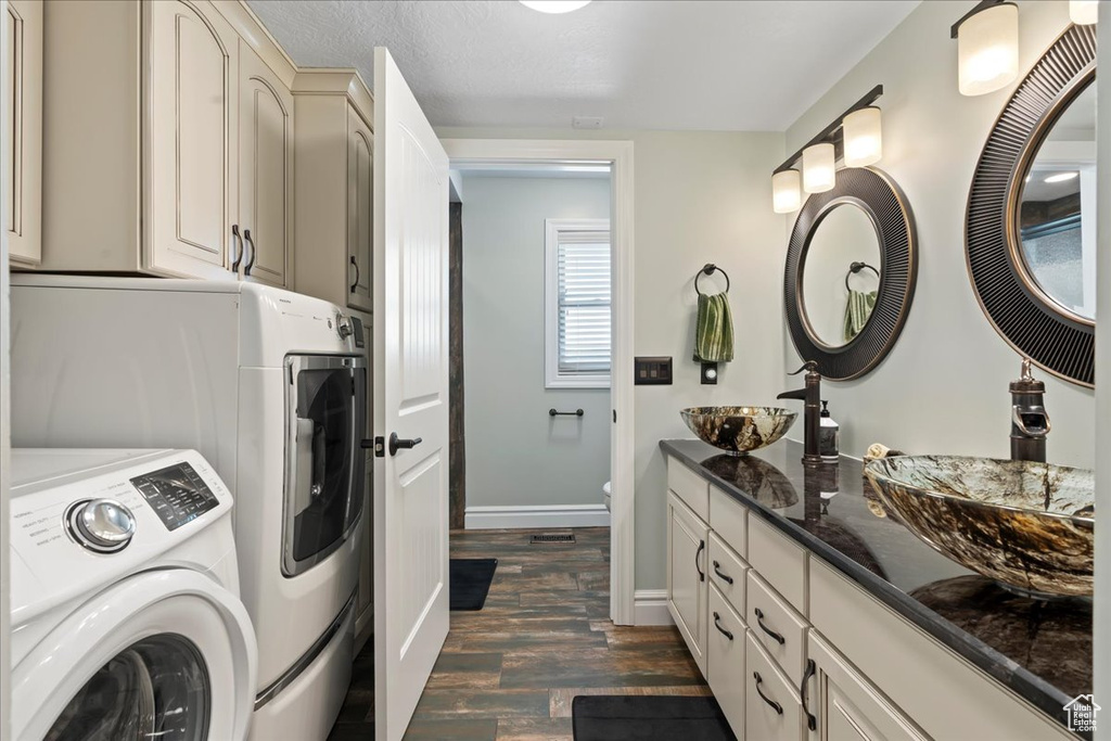 Clothes washing area featuring sink, dark hardwood / wood-style flooring, and separate washer and dryer