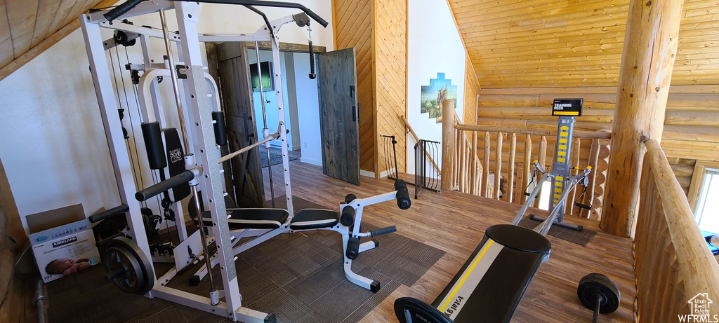 Exercise area with dark hardwood / wood-style flooring and vaulted ceiling