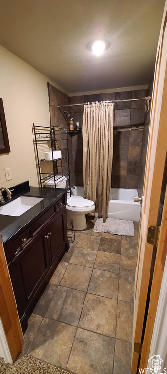 Full bathroom featuring tile floors, vanity, toilet, and shower / tub combo