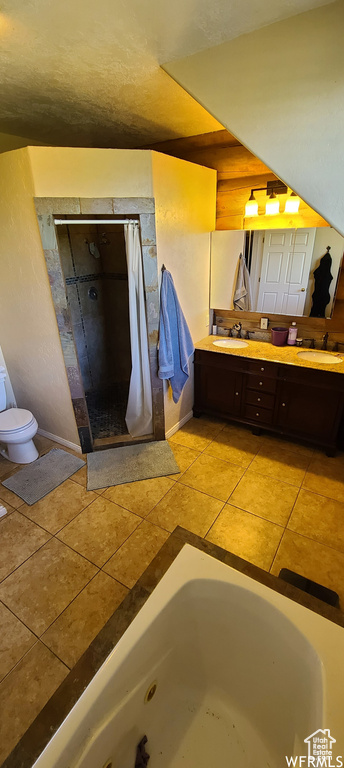 Full bathroom featuring toilet, double sink vanity, shower with separate bathtub, and tile floors
