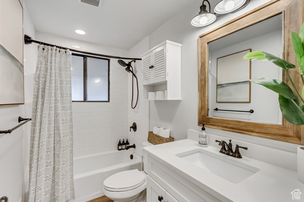 Full bathroom featuring vanity, toilet, and shower / tub combo with curtain