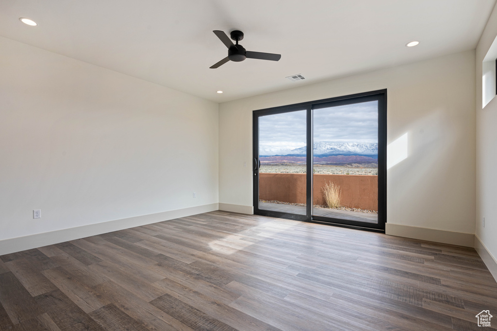 Spare room with plenty of natural light, dark hardwood / wood-style flooring, and ceiling fan