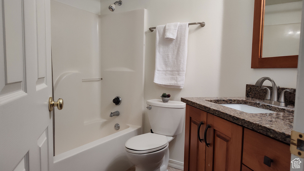 Full bathroom with shower / bathing tub combination, large vanity, and toilet