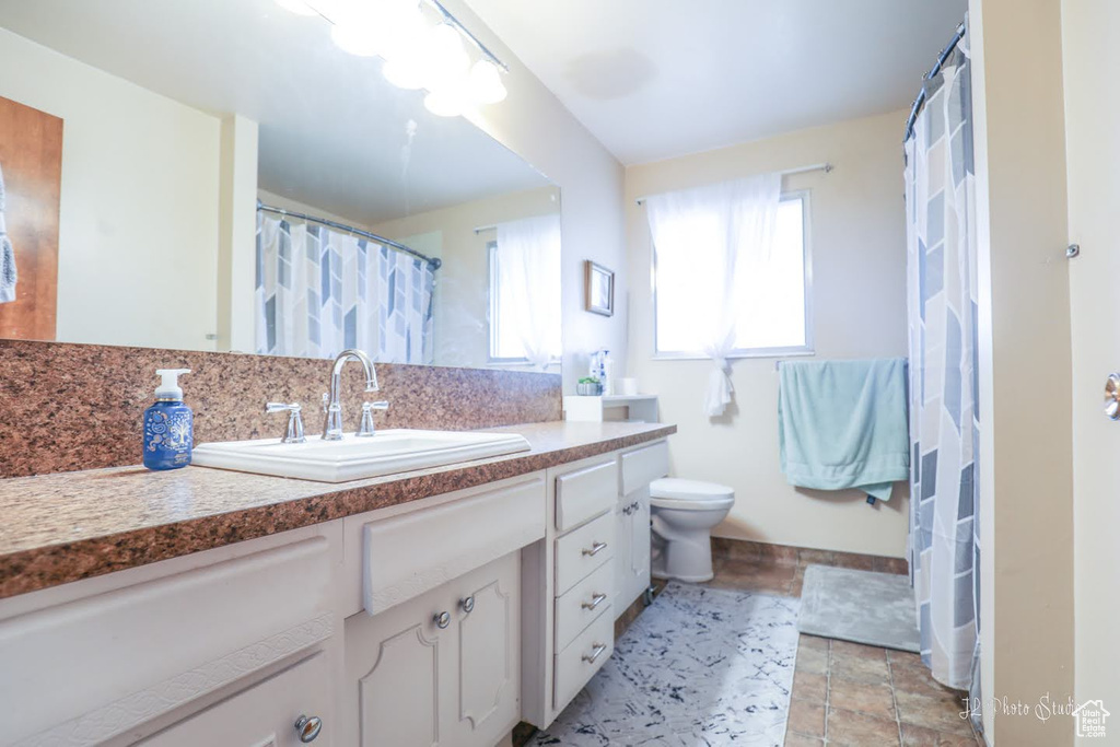 Bathroom with oversized vanity, tile floors, and toilet
