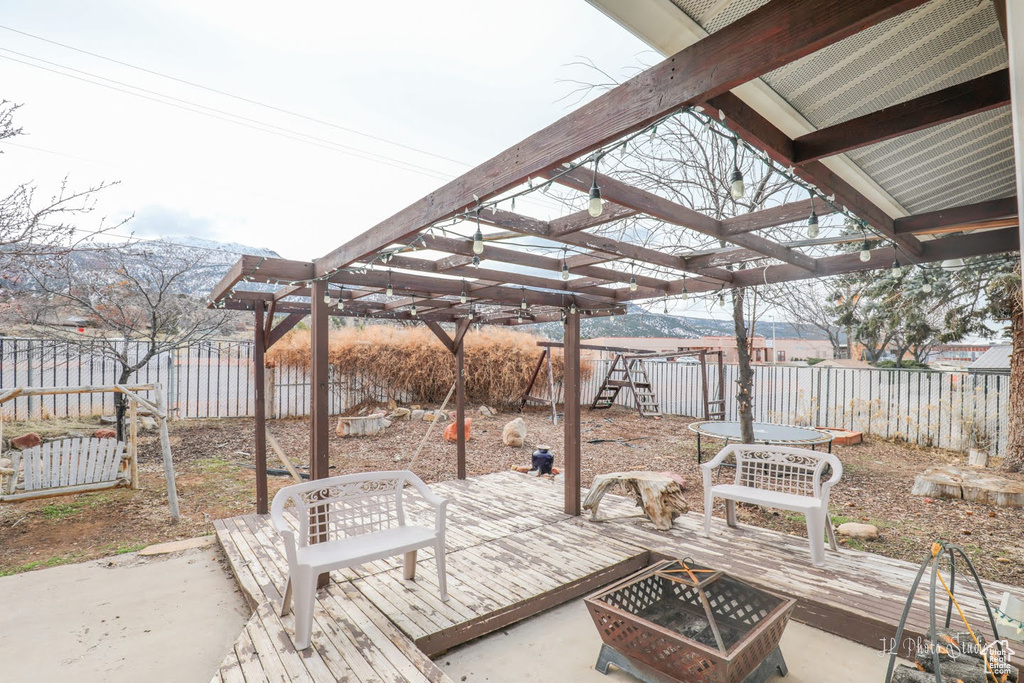 View of patio with a pergola, a deck, and an outdoor fire pit
