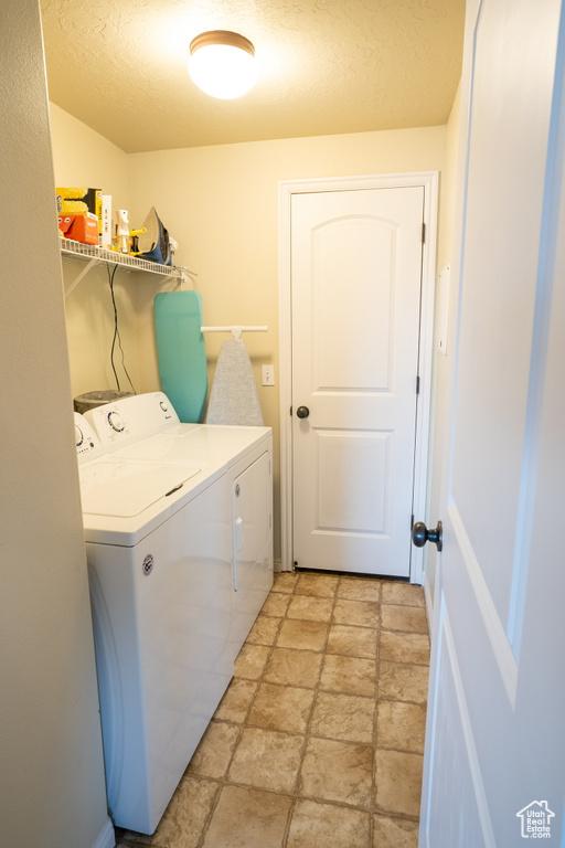 Laundry room with light tile flooring and washer and dryer