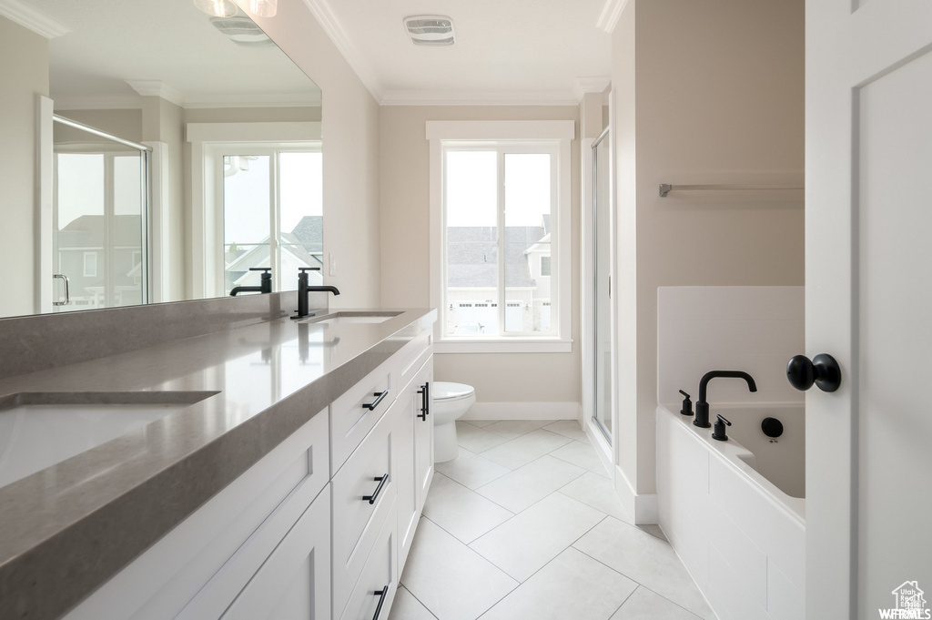Full bathroom featuring a wealth of natural light, toilet, tile flooring, and crown molding