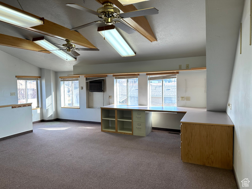 Interior space with vaulted ceiling with beams, carpet floors, a textured ceiling, and ceiling fan