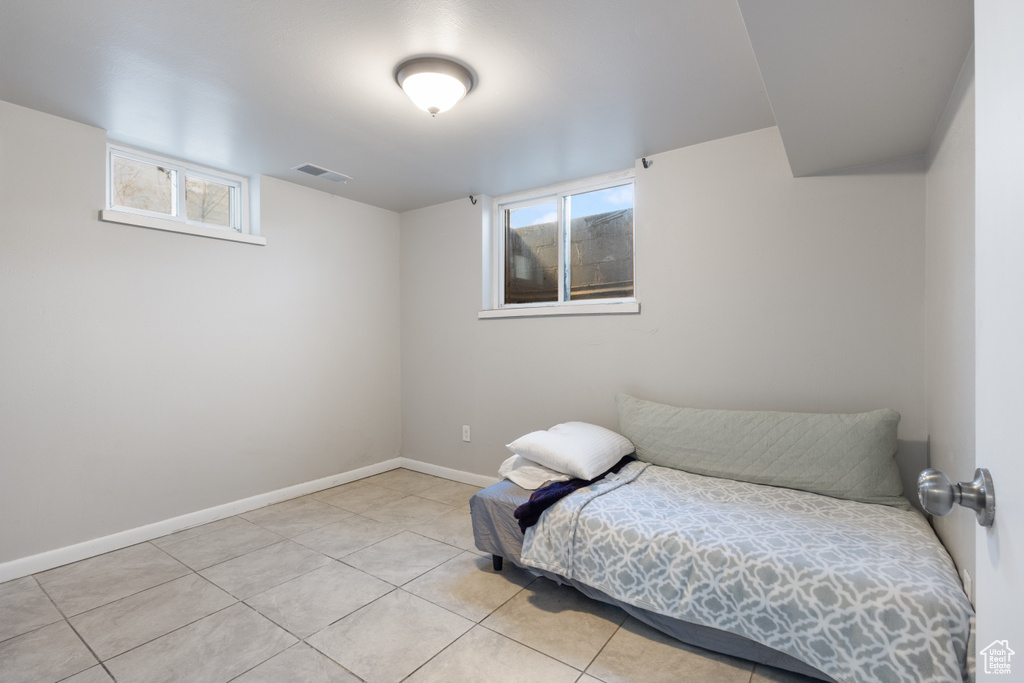 Unfurnished bedroom with light tile floors and multiple windows