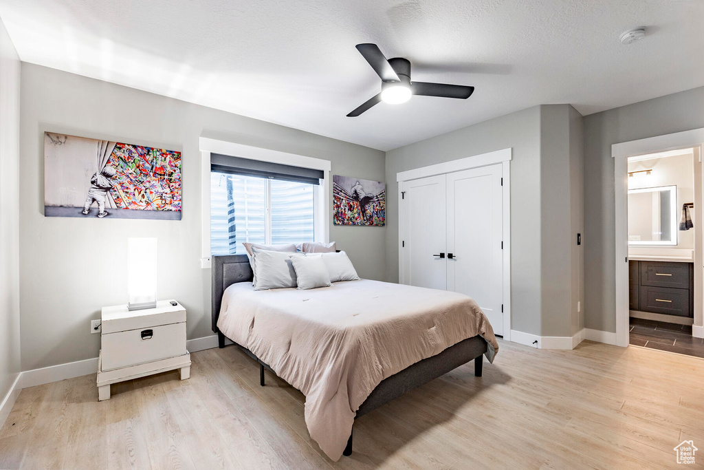 Bedroom featuring ensuite bath, light hardwood / wood-style flooring, a closet, and ceiling fan