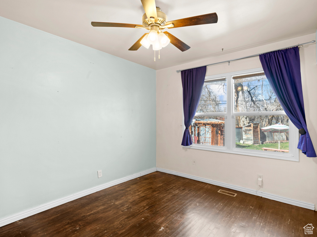 Unfurnished room with ceiling fan and dark wood-type flooring