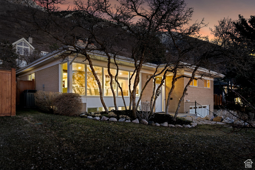 Property exterior at dusk featuring a yard