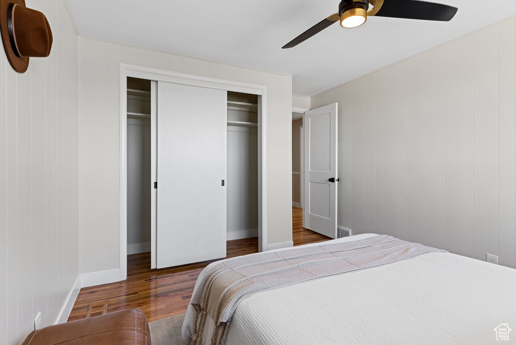 Bedroom featuring ceiling fan, dark hardwood / wood-style flooring, and a closet