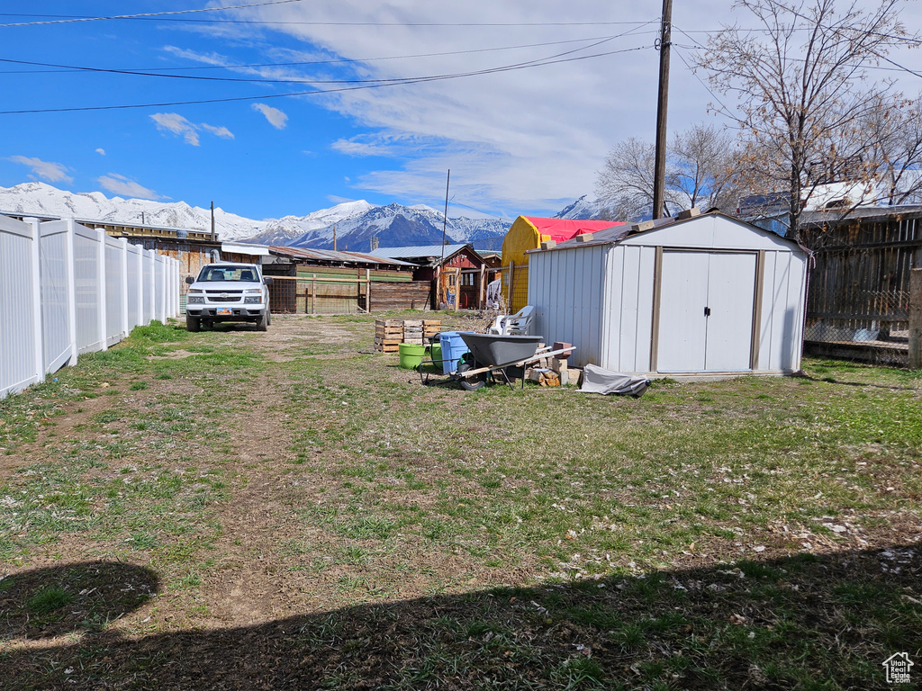 View of yard with a mountain view and a storage shed