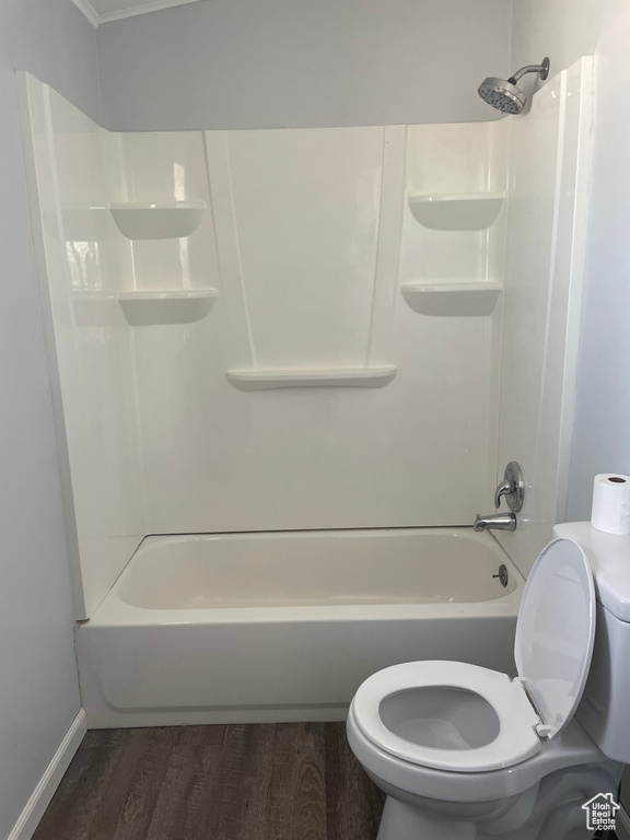 Bathroom with hardwood / wood-style floors, toilet, and shower / bathtub combination