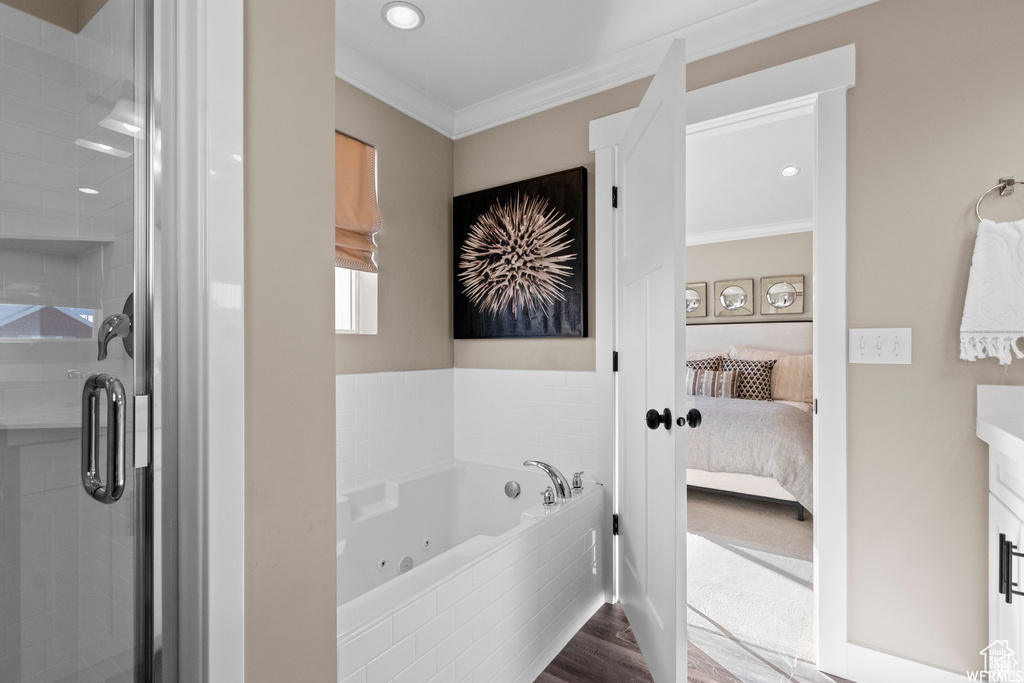 Bathroom featuring vanity, hardwood / wood-style floors, shower with separate bathtub, and ornamental molding