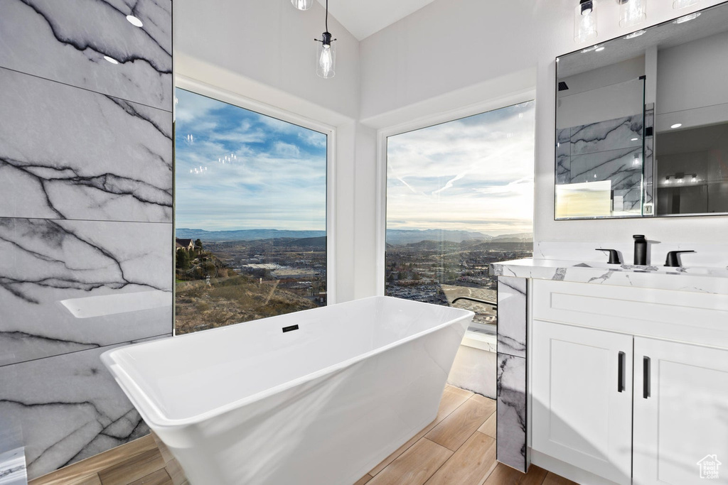 Bathroom featuring vanity, a tub, and hardwood / wood-style floors