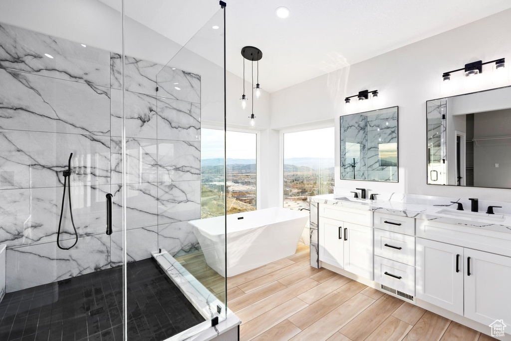 Bathroom featuring independent shower and bath, dual sinks, hardwood / wood-style flooring, large vanity, and a mountain view