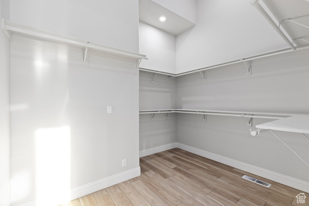 Spacious closet featuring light hardwood / wood-style flooring