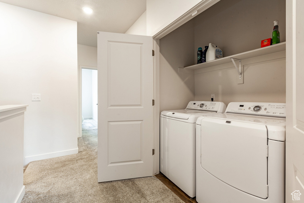 Washroom featuring light carpet and separate washer and dryer