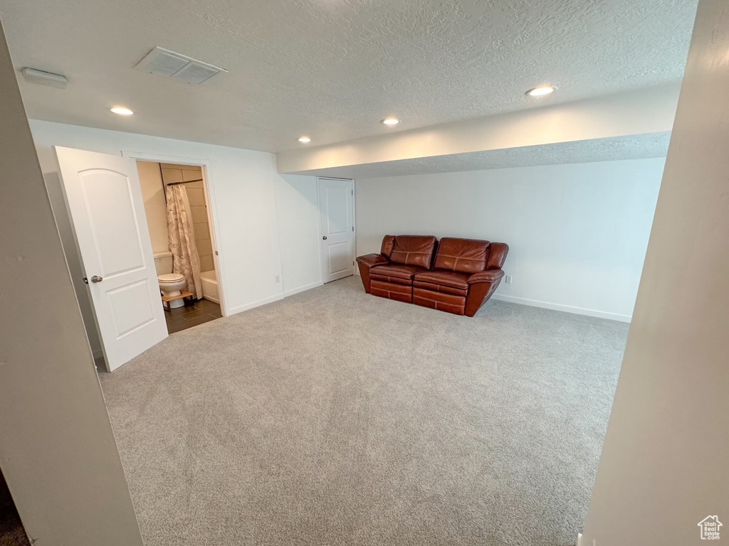 Living area featuring a textured ceiling and light colored carpet