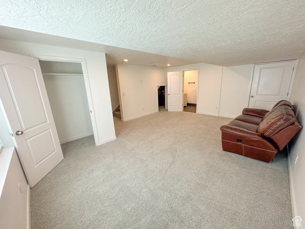 Living area with light colored carpet and a textured ceiling
