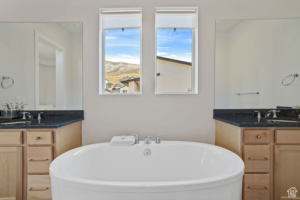 Bathroom featuring double sink vanity and a bathing tub