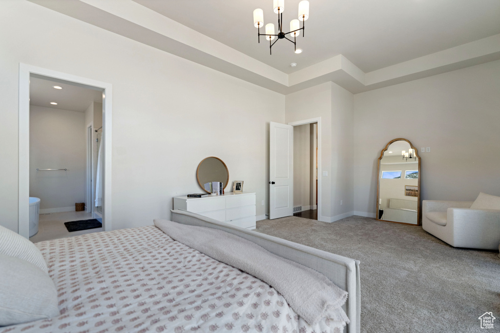 Bedroom with a notable chandelier, light carpet, and ensuite bath