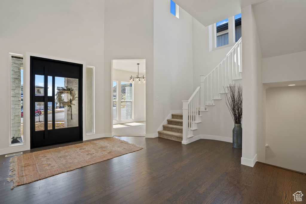 Entryway featuring a notable chandelier, dark hardwood / wood-style flooring, and a high ceiling