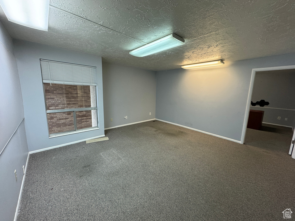 Interior space featuring a textured ceiling and dark carpet