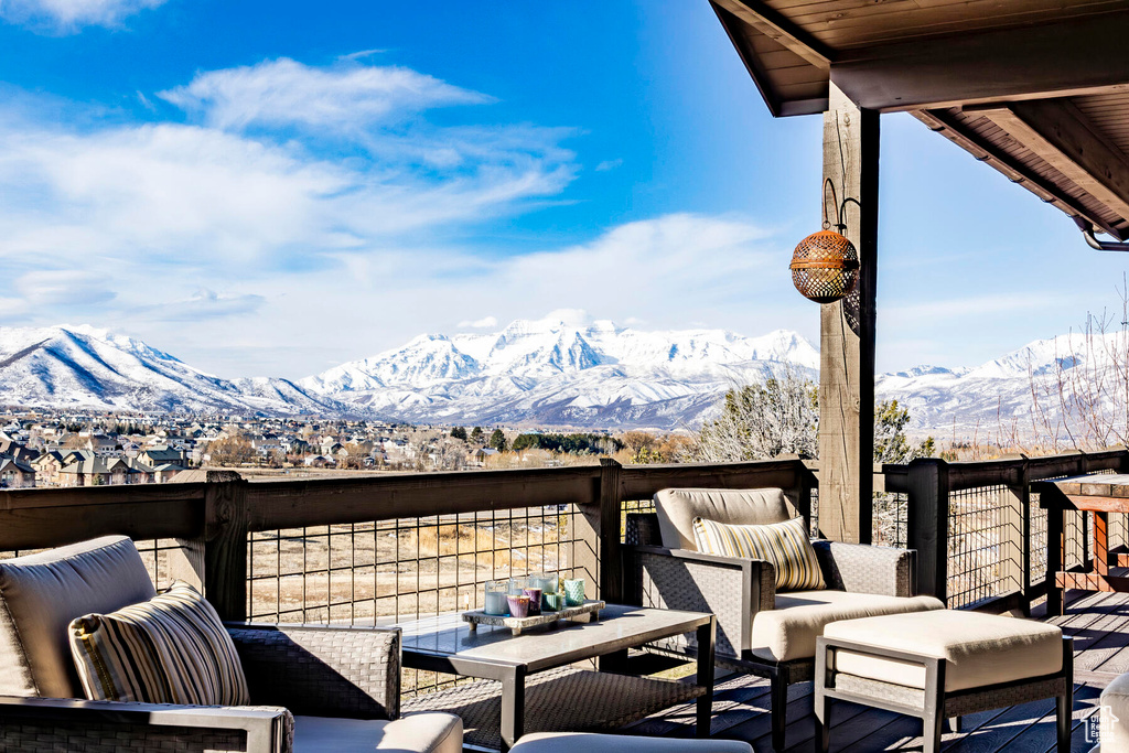 Snow covered deck with a mountain view and outdoor lounge area